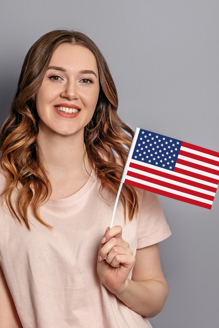 Study In USA, Cubeloid Overseas Consultants, foreign university, Student holding USA Flag