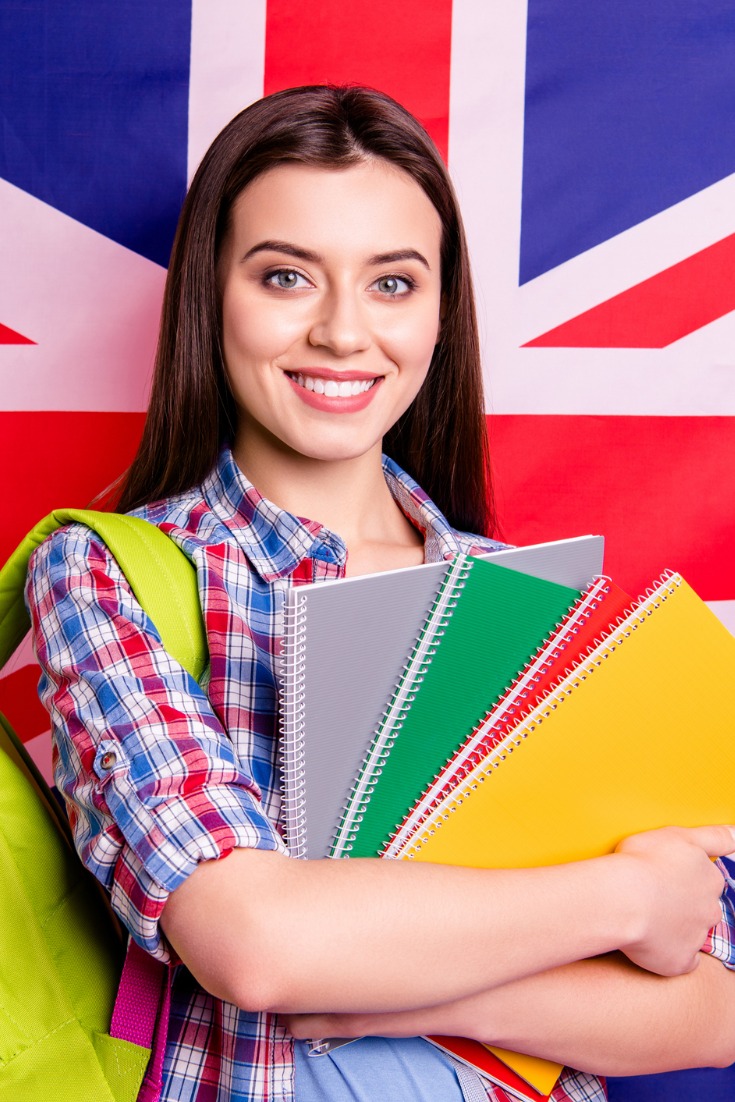 Study In UK, Cubeloid Overseas Consultants, foreign university, Student standing in front of UK Flag